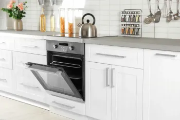 Modern kitchen with sleek white cabinetry, stainless steel oven, and stylish backsplash, showcasing Bayside Builders Group's expertise in Bay Area kitchen renovations and home improvements.