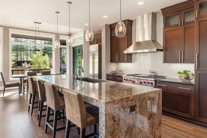 Luxurious modern kitchen remodel featuring a spacious marble island, sleek stainless steel appliances, and elegant pendant lighting, exemplifying Bayside Builders Group's expertise in Bay Area home renovations.
