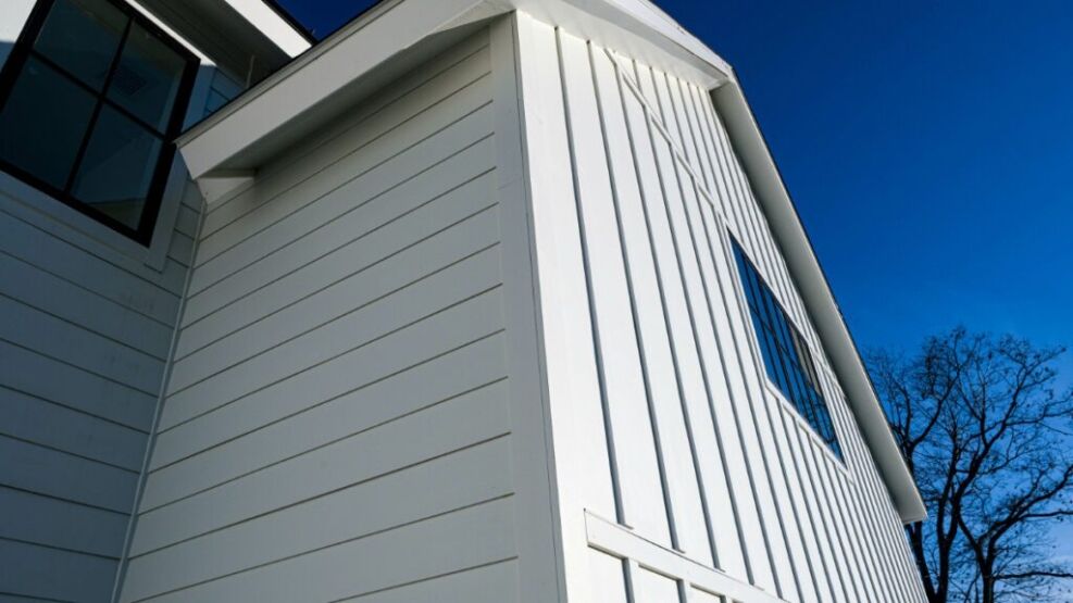 A modern residential building with white siding and a sleek window, showcasing Bayside Builders Group's expertise in high-quality siding and exterior home renovations in the Bay Area.